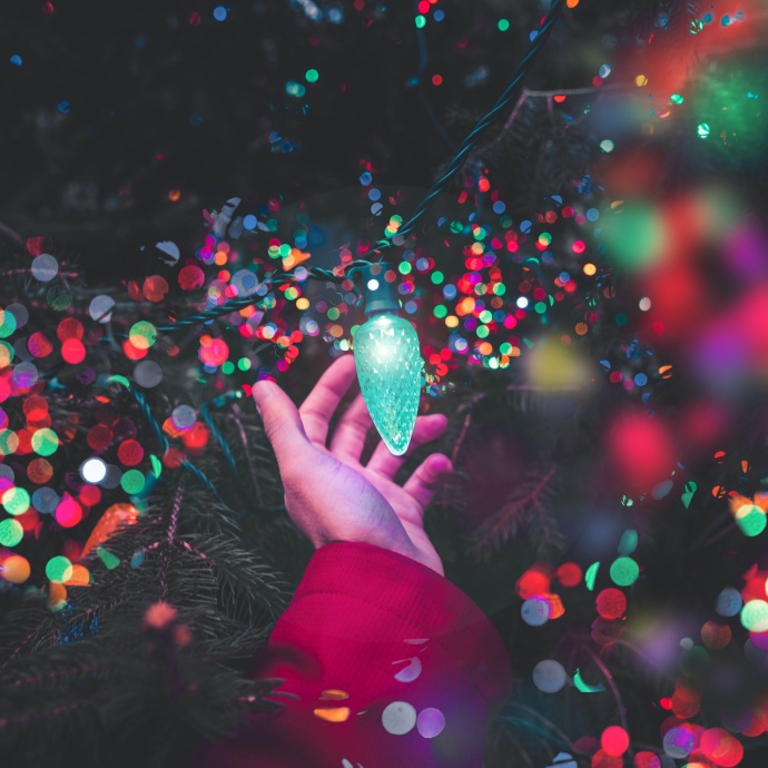 Iluminación navideña colorida en la mano