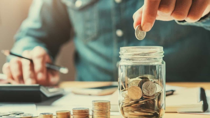 Hombre poniendo moneda en hucha