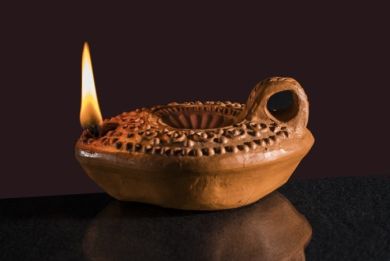 Ancienne bougie en argile avec flamme