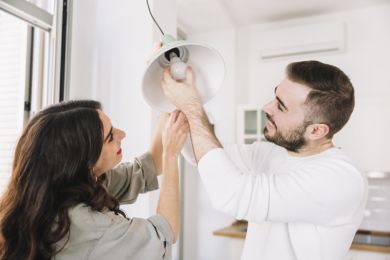 Young couple changing a light bulb