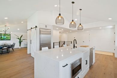 White kitchen island with overhead light fixtures