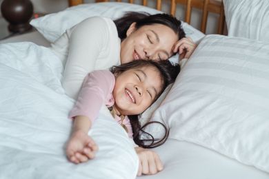 Smiling mother and daughter sleeping Smiling mother and daughter sleeping