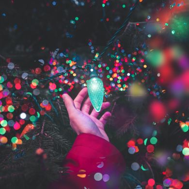 Iluminación navideña colorida en la mano
